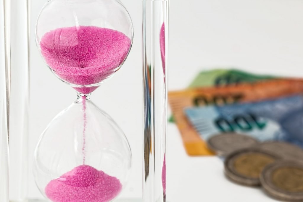 An hourglass with money.