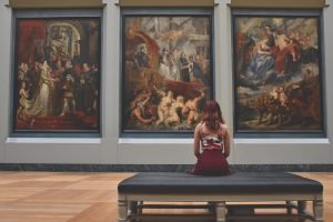 A woman sitting and enjoying paintings
