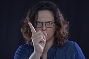 A woman with glasses in blue shirt. 