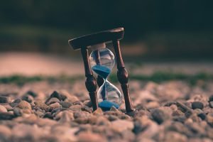An hourglass on a surface of rocks 