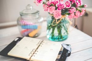 Moving - out checklist with notebook and flowers. 