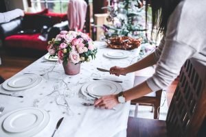 Woman preparing table for meal. 