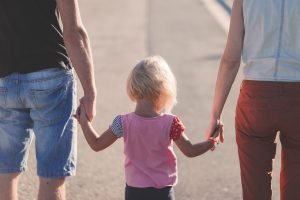 Parents holding their childs hand. One of the best unpacking tips and hacks is to make unpacking enjoyable for your children.