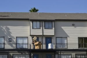 man carrying moving boxes into the house