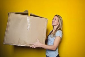 a girl carrying moving box